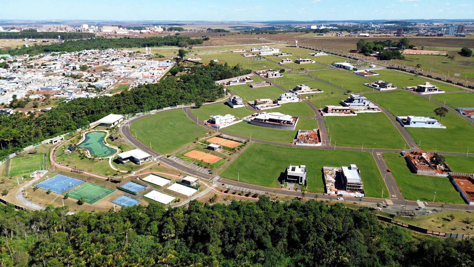 Vista aérea do empreendimento cercado pela cidade e pela mata