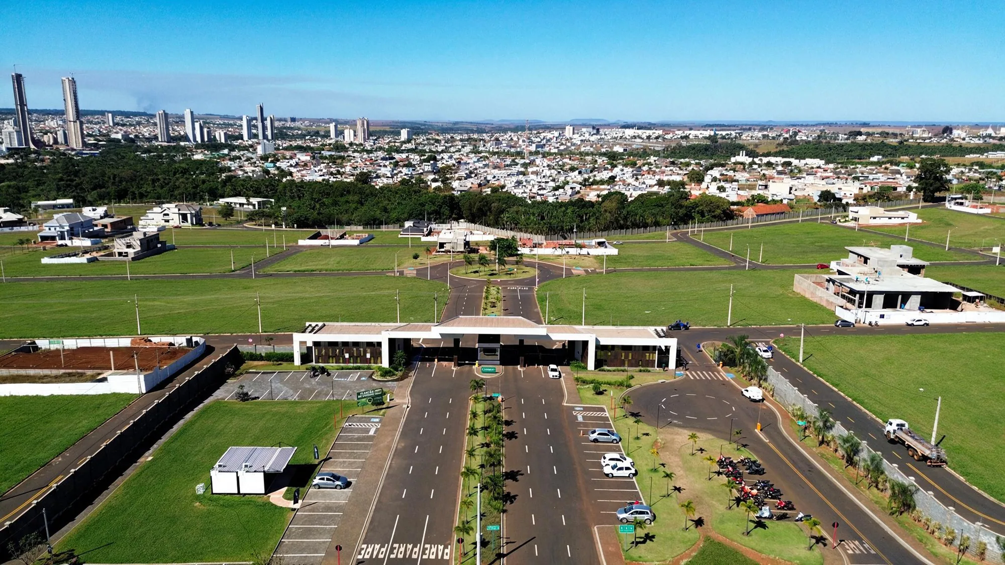 Vista aérea ampla da portaria e da chegada ao condomínio